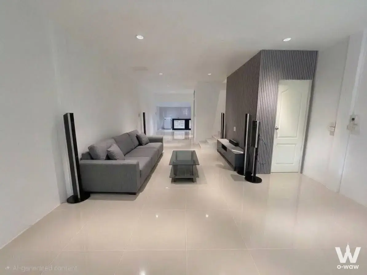 Spacious living room in 3-bed townhouse for rent at The Exclusive Townhome with grey sectional sofa and dark slat accent wall