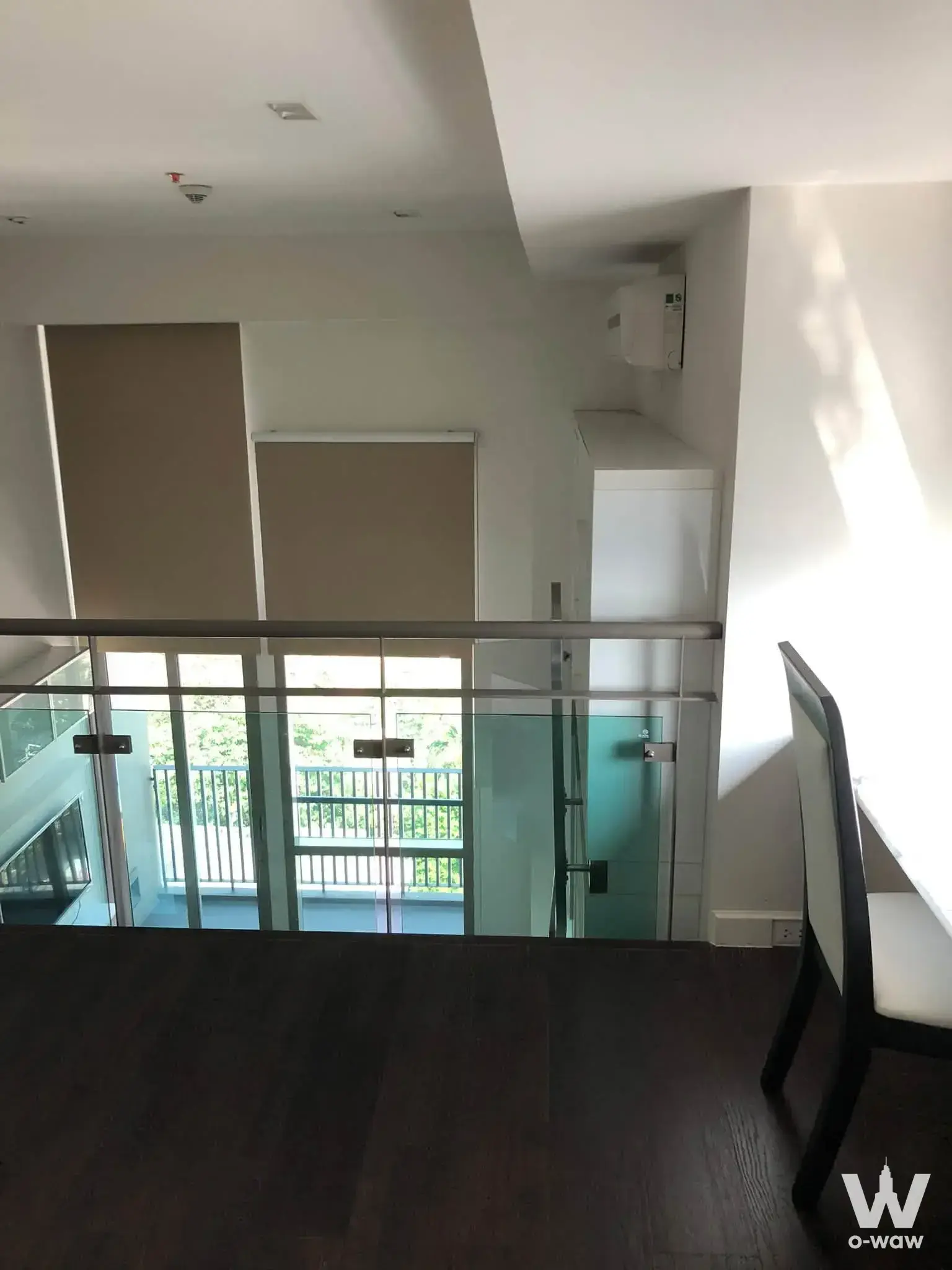 Ashton Morph 38 duplex condo with dark wood floors and glass balustrade overlooking the lower level
