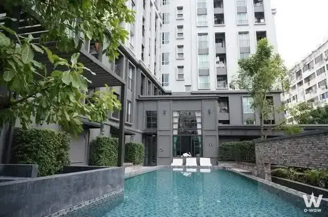 Rectangular pool with blue water and dark gray tiles at Chapter One Shine Bangpo 1-bed condo for sale
