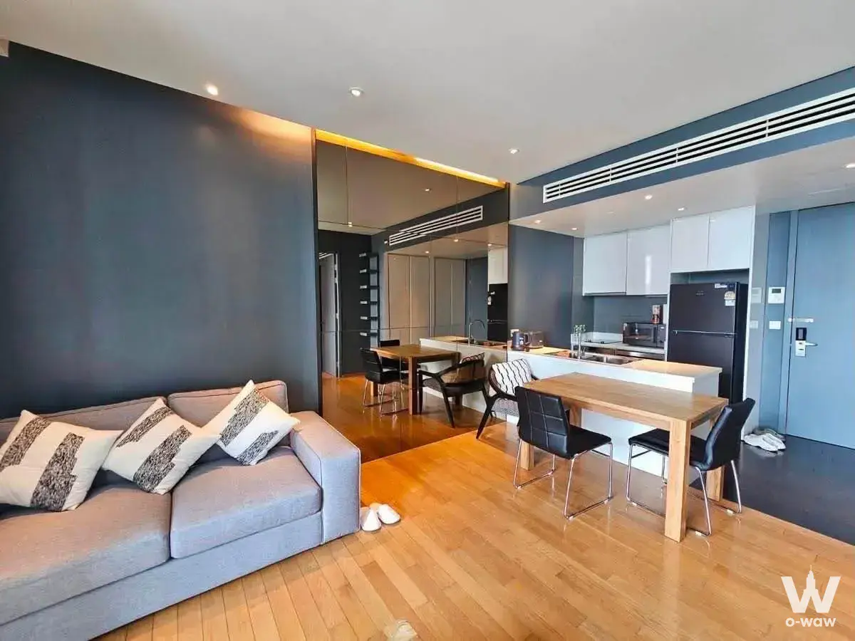 Modern 1-bed condo for rent in Supalai Park Ekkamai featuring an open-plan living area with charcoal grey and light oak