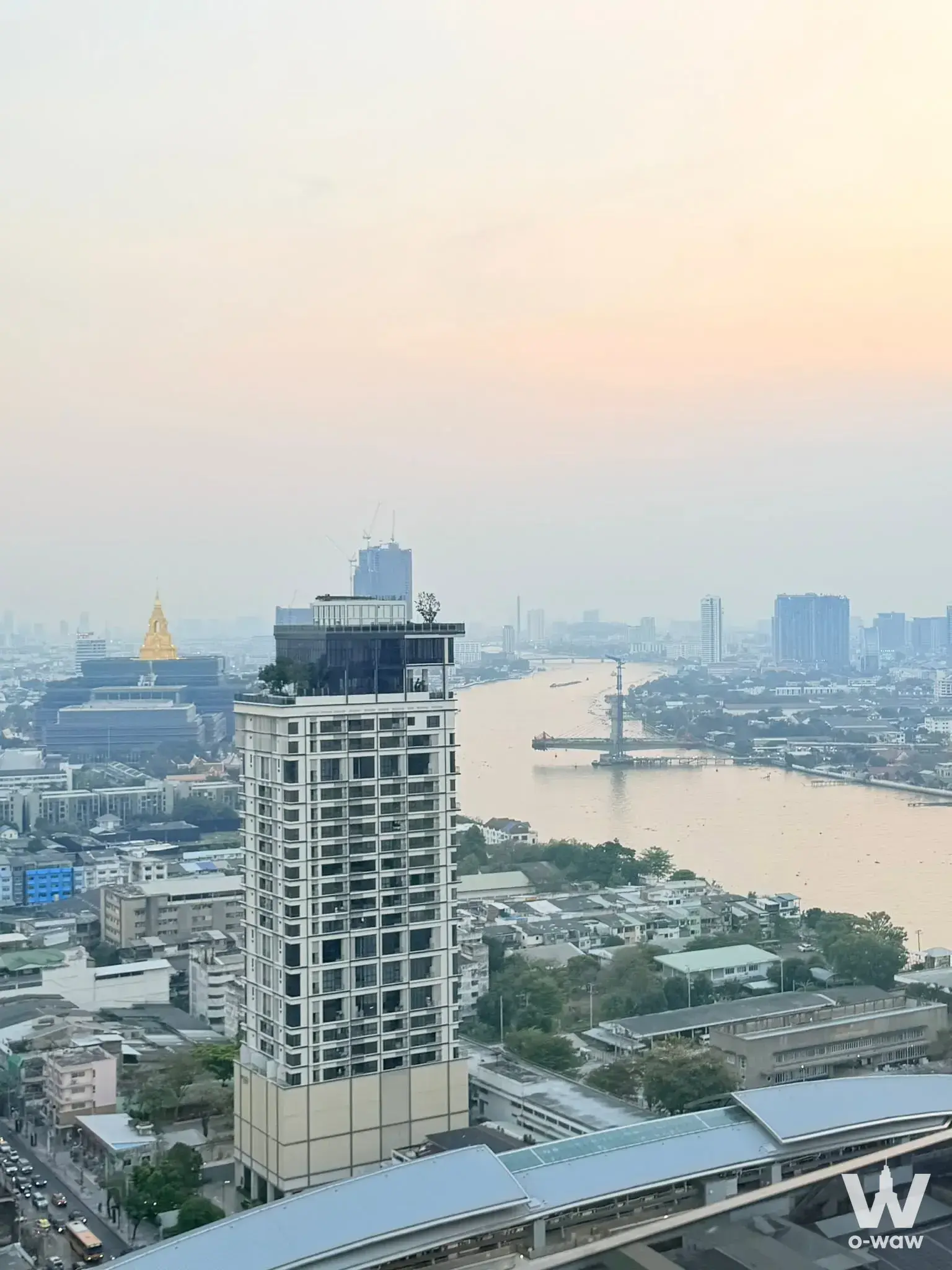 High-rise view from 1-bed condo for sale in The Tree Bang Po Station showing river and golden spire at dusk