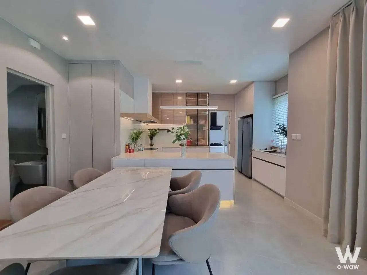 Open-plan dining area in a 4-bed house for rent in Mantana Bangna with marble table and LED-lit island