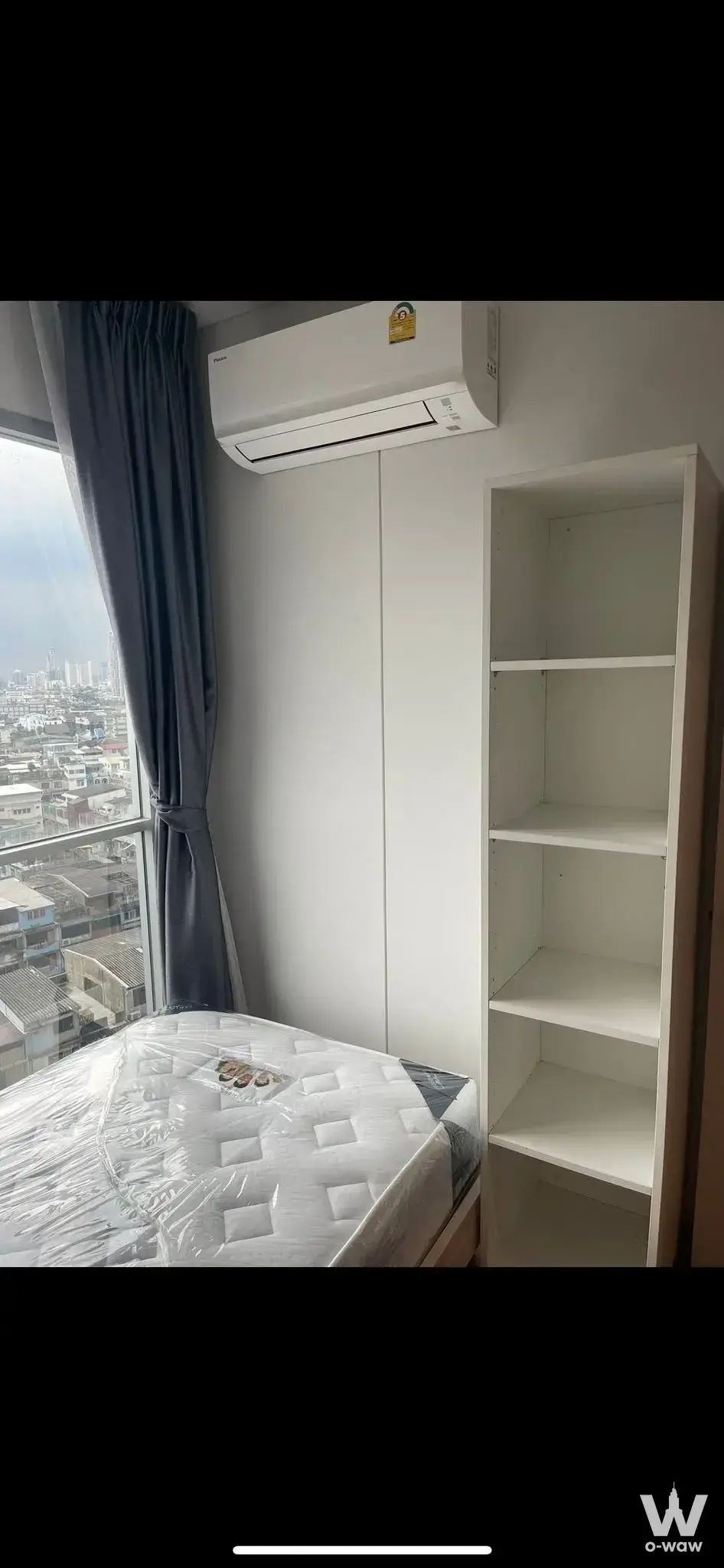 Modern bedroom in Lumpini Place Ratchada-Sathu condo with city view, AC, and built-in wardrobe