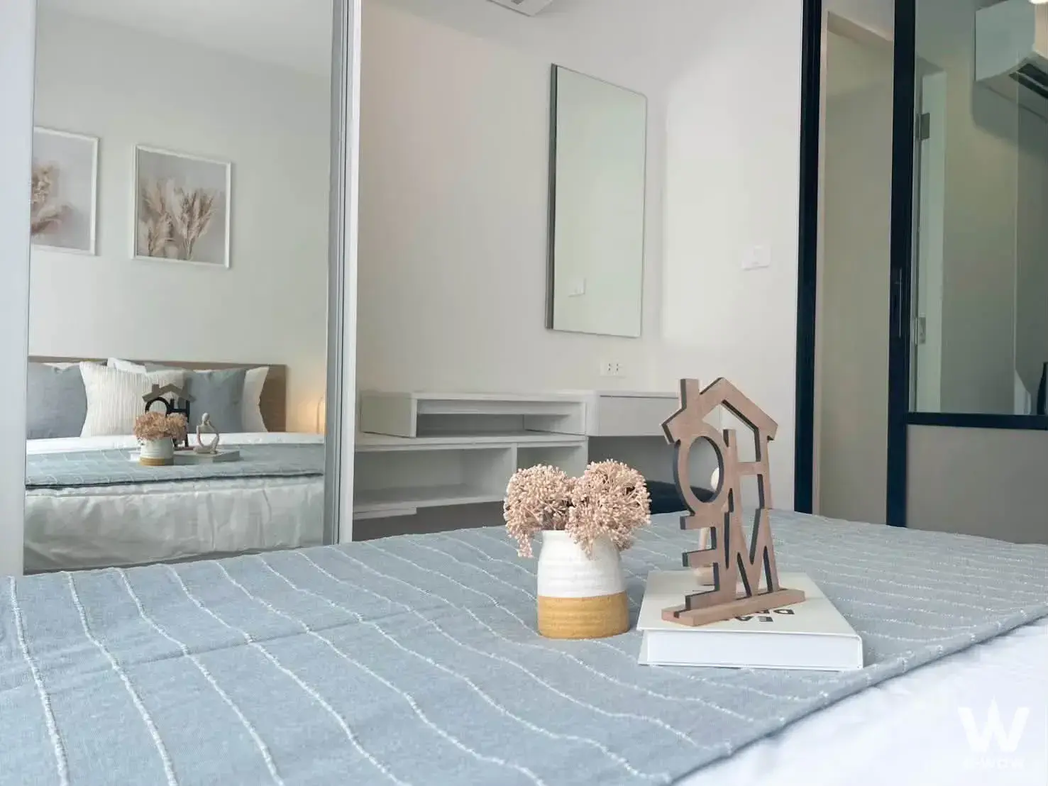 Minimalist bedroom in Kave Wonderland featuring light-blue bedding and mirrored wardrobe