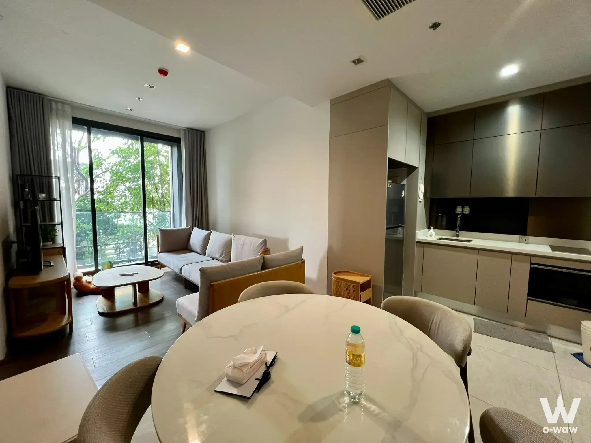 Modern open-plan living and dining area in 2-bed condo for sale at The Address Siam-Ratchathewi with balcony view