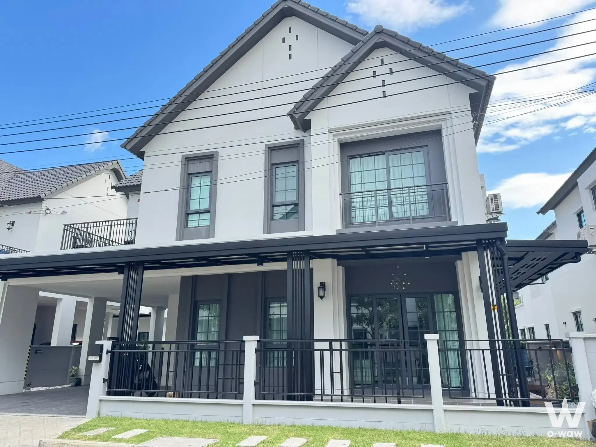 Modern 4-bed house for sale in Centro Bangna with white facade, black carport, and balcony
