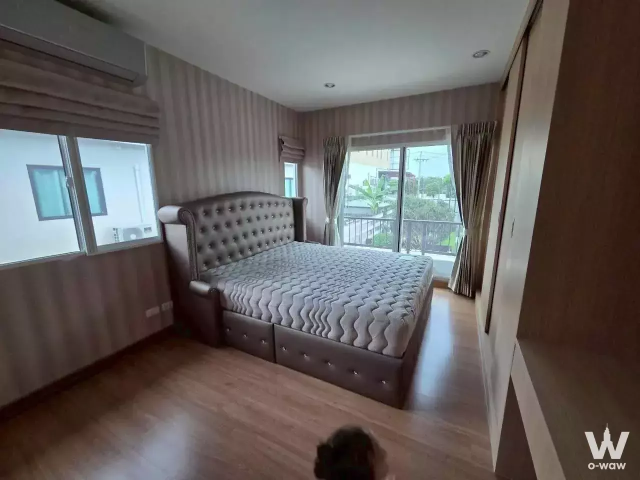 Modern bedroom in Passorn Prestige Luxe Pattanakarn 44 with grey sleigh bed and balcony access