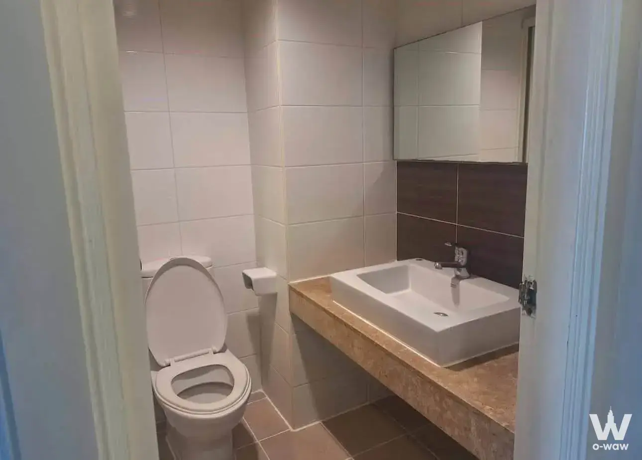 Modern bathroom with glossy white wall tiles, beige stone vanity, vessel sink, and wood-look backsplash