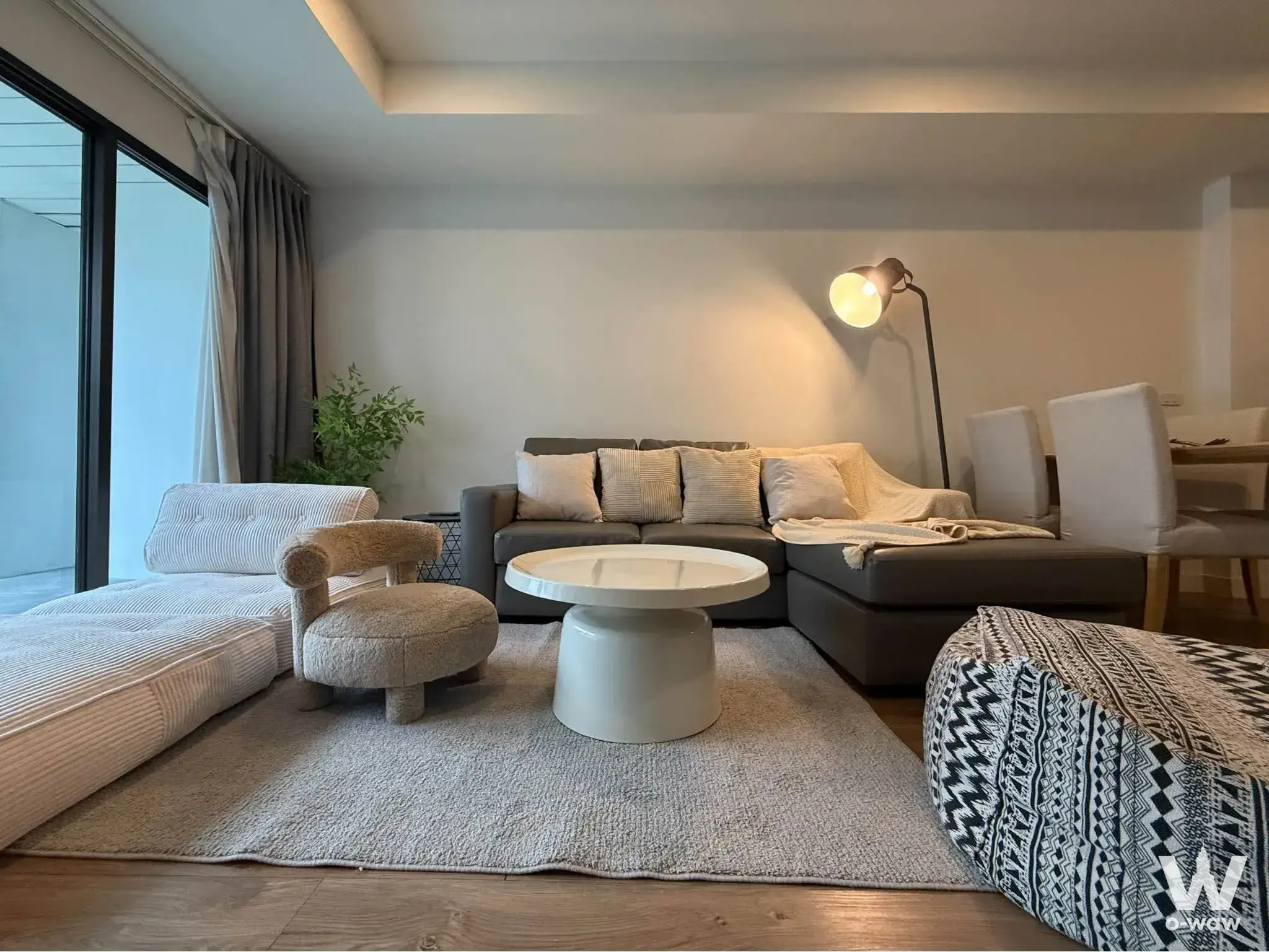 Modern living room with grey sectional sofa and floor-to-ceiling windows at The Natural Place Suite
