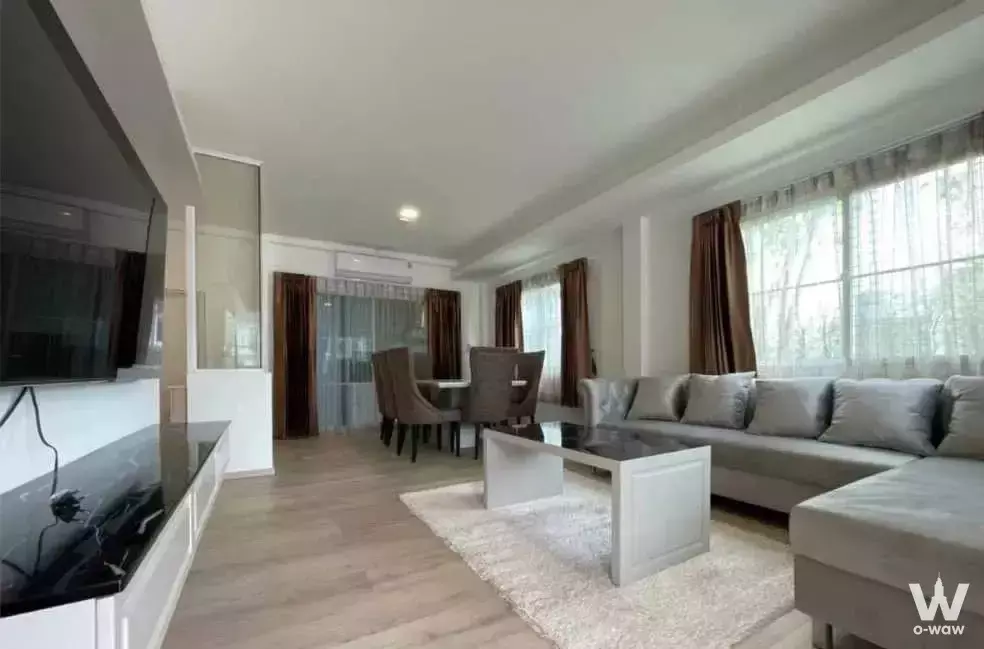 Spacious open-plan living and dining area with grey sectional sofa and large windows in 4-bed townhouse for sale in Indy 2
