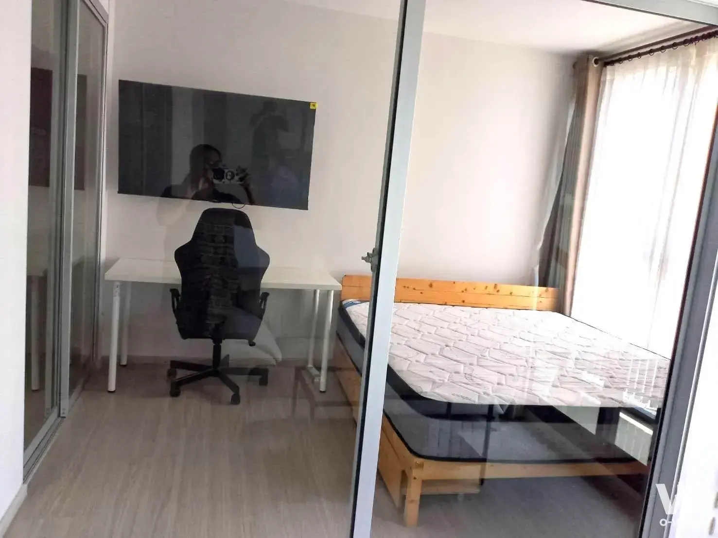 Bright bedroom in 1-bed condo for rent at The Parkland Phetkasem 56 with desk, TV, and bed
