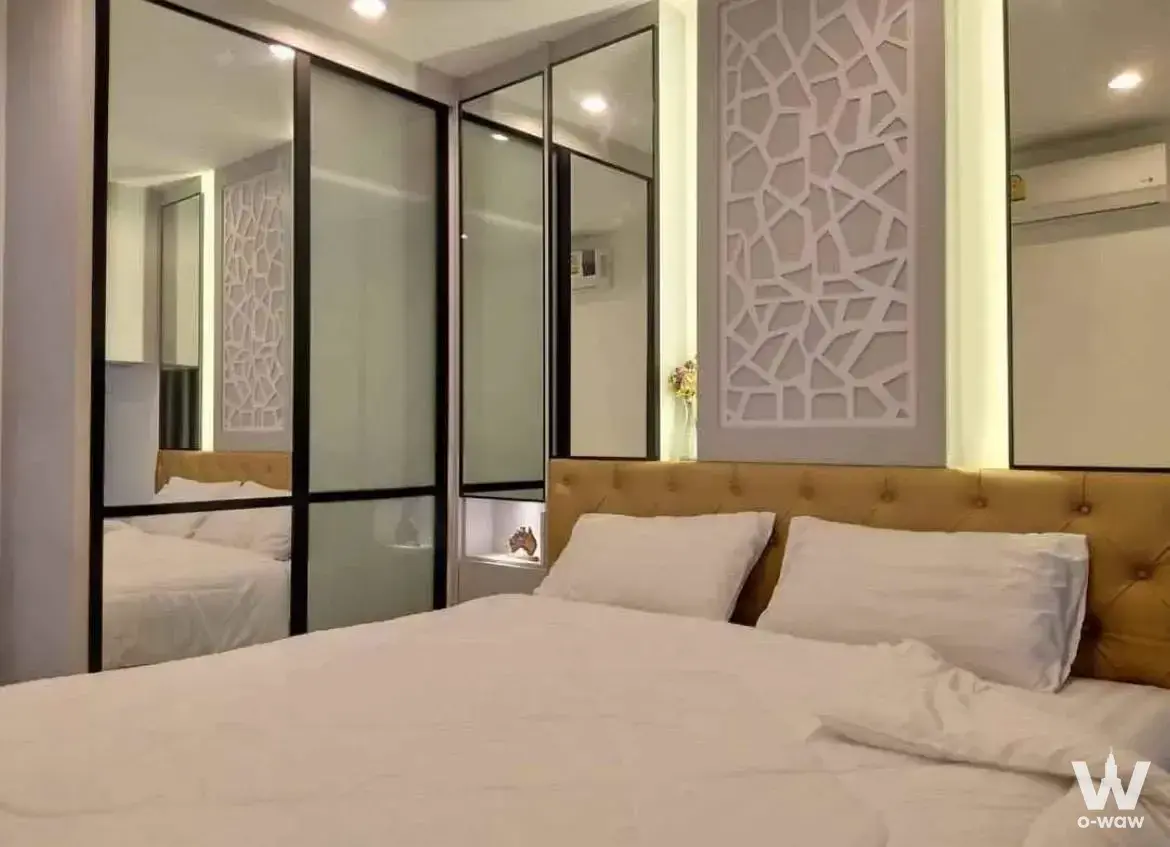 Queen bed with mustard headboard in bright 1-bed condo for rent at Ideo Mobi Wongsawang Interchange