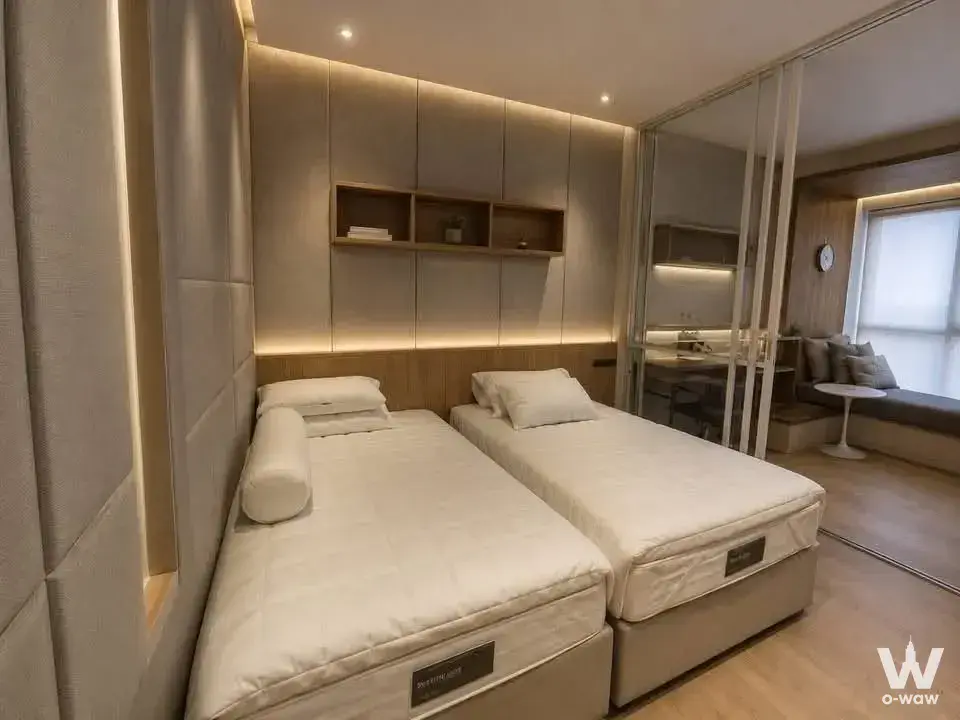 Triple Y Residence bedroom with dual beds, LED headboard lighting, and mirrored wardrobe reflecting living area