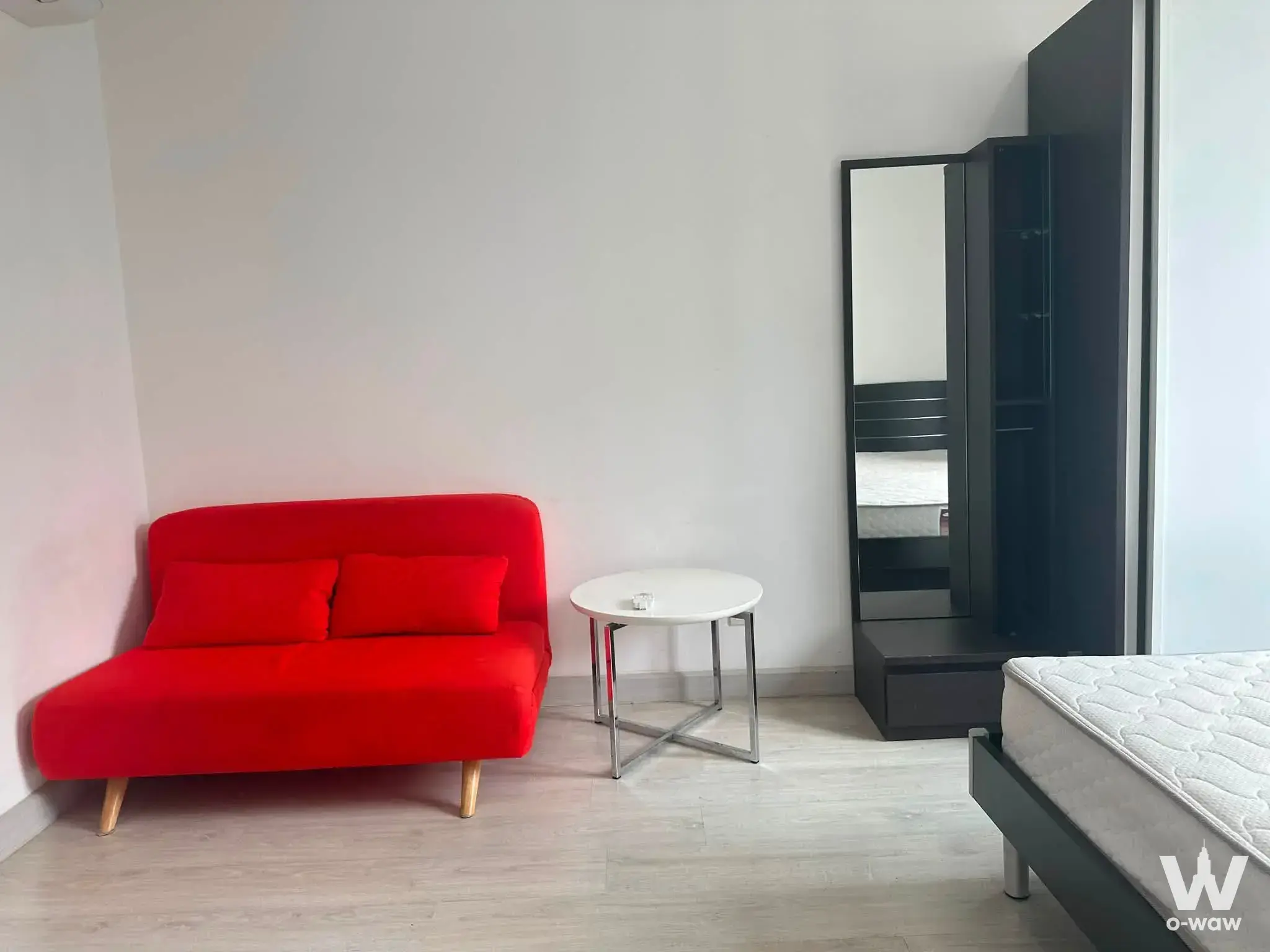 Bright bedroom in Ideo Mobi Sukhumvit 81 with red sofa and charcoal wardrobe unit