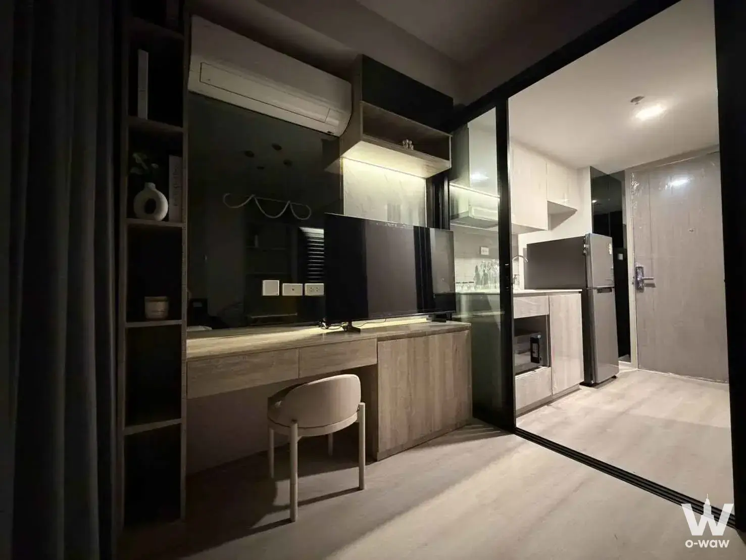 Living room with dark grey walls and open-plan kitchen in 1-bed condo for rent at COBE Ratchada-Rama 9