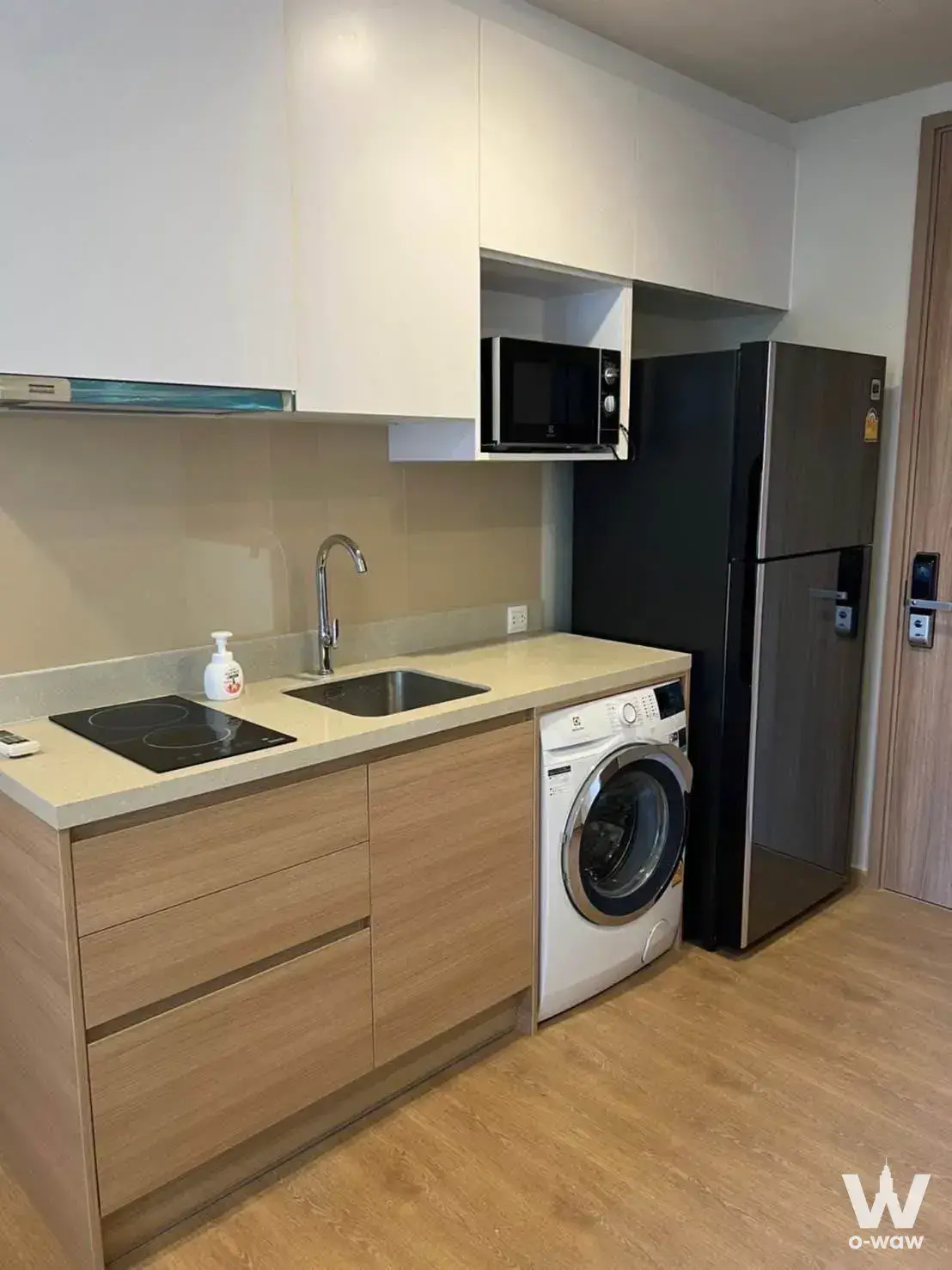 Modern kitchenette in 1-bed condo for rent at Noble Around Sukhumvit 33 with wood cabinetry