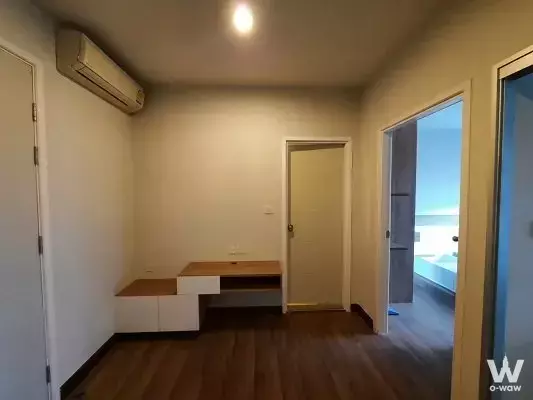 Modern 1-bed condo bedroom in Centric Tiwanon with wood floors, built-in desk, and open bathroom view