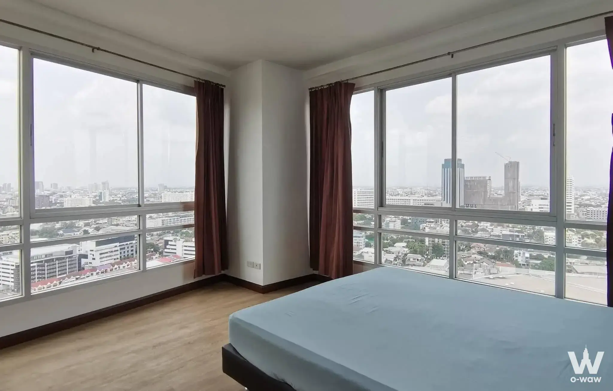Corner unit bedroom at The Zest Condominium with floor-to-ceiling windows and city views