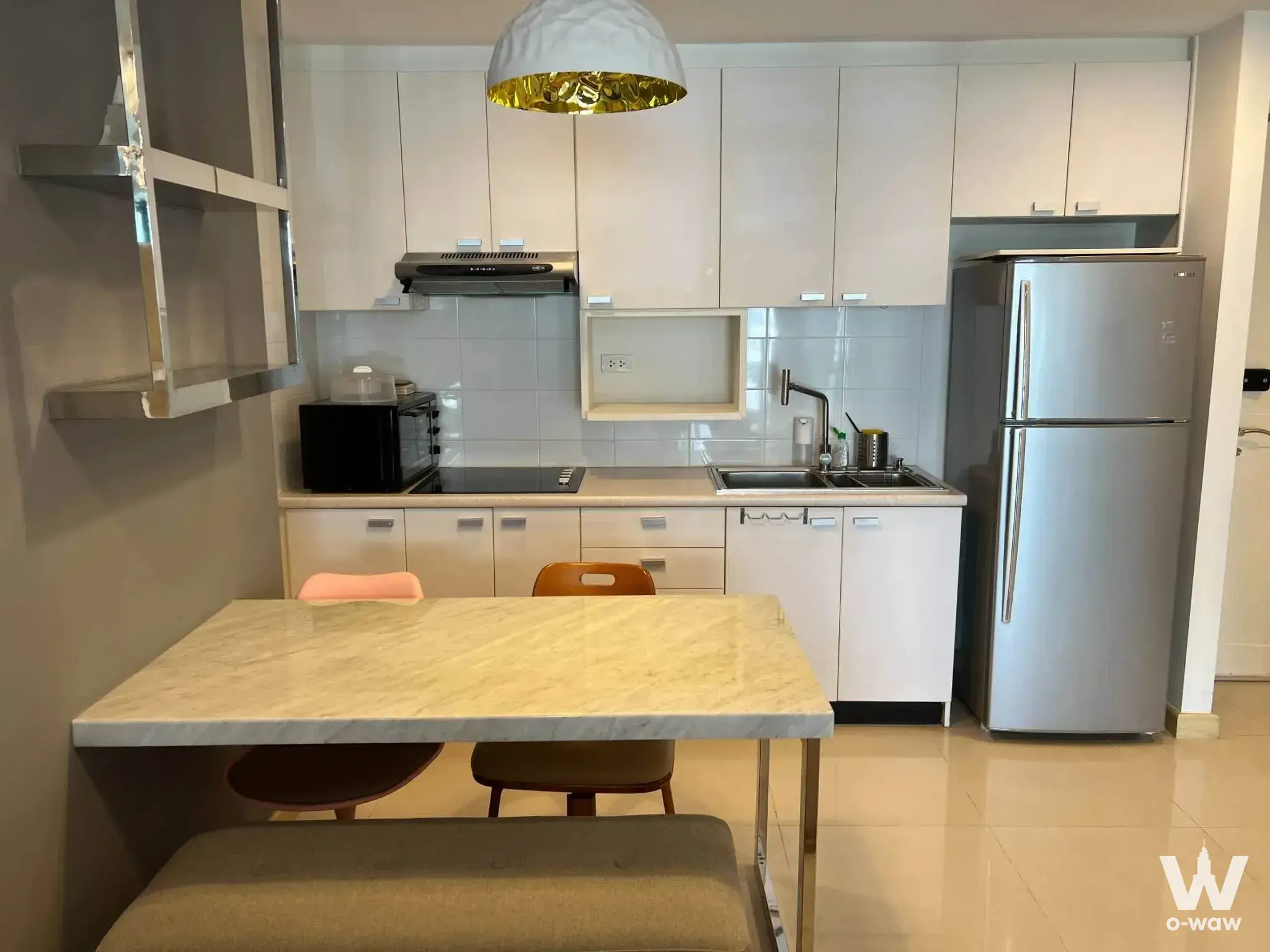 Harmony Living 1-bed house kitchen dining area with white cabinets and marble-look table