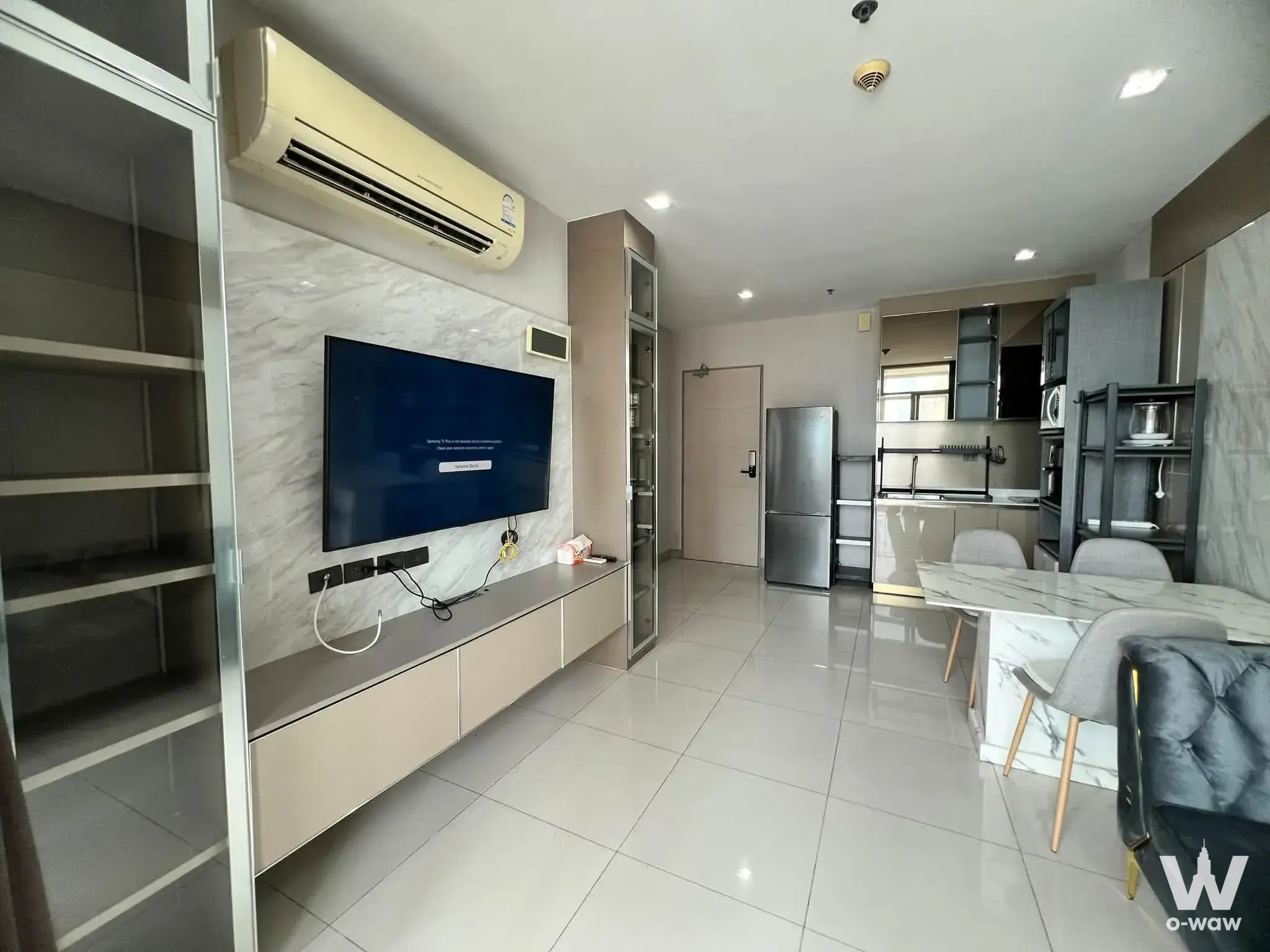 Open-plan living area with marble TV wall and dining set in an Ideo Verve Ratchaprarop 2-bed condo