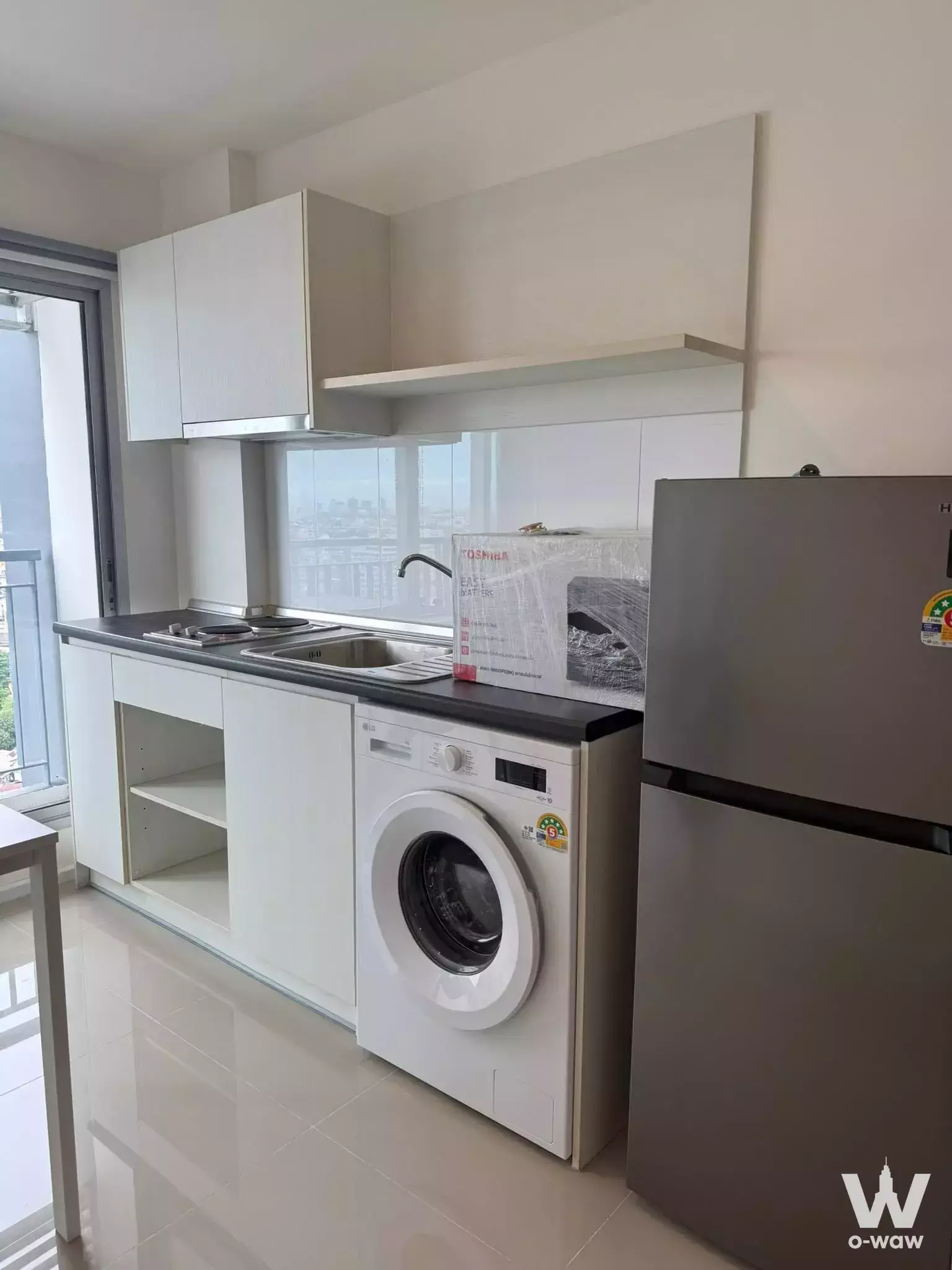 Modern kitchenette in 1-bed condo for rent at Aspire Sukhumvit 48 with white cabinets, gas cooktop, and balcony access
