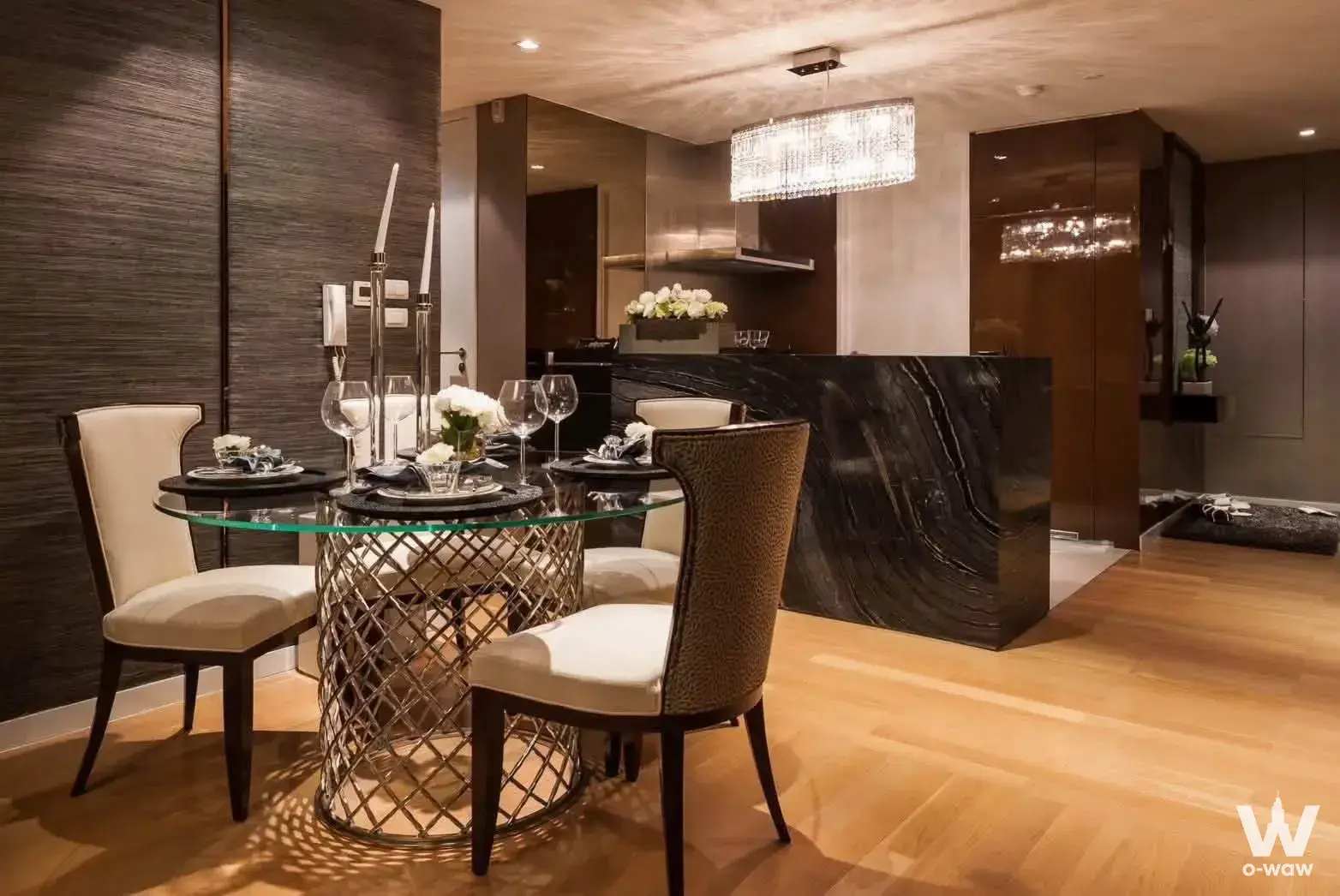 Luxury dining area in The Pano condo featuring a glass table, marble island, and herringbone flooring