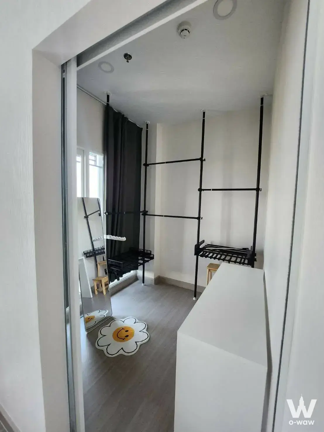 Modern utility room in Supalai Loft Sathon-Ratchaphruek with black shelving and smiley face rug