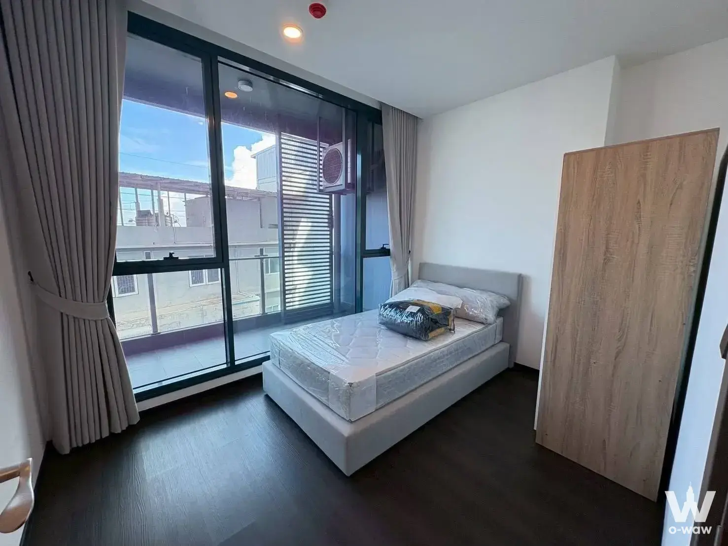 Sapphire Condominium bedroom with bed, wardrobe, and balcony view