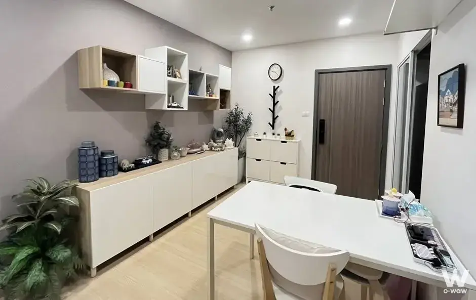 Modern dining and living area in 2-bed Supalai Veranda Ramkhamhaeng condo with light wood floors and white furniture