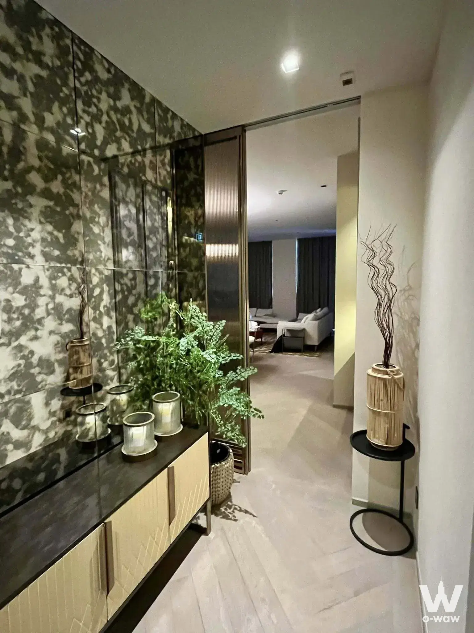 Entry foyer in The Reserve Sathorn 2-bed condo with dark marble wall and herringbone tile floor