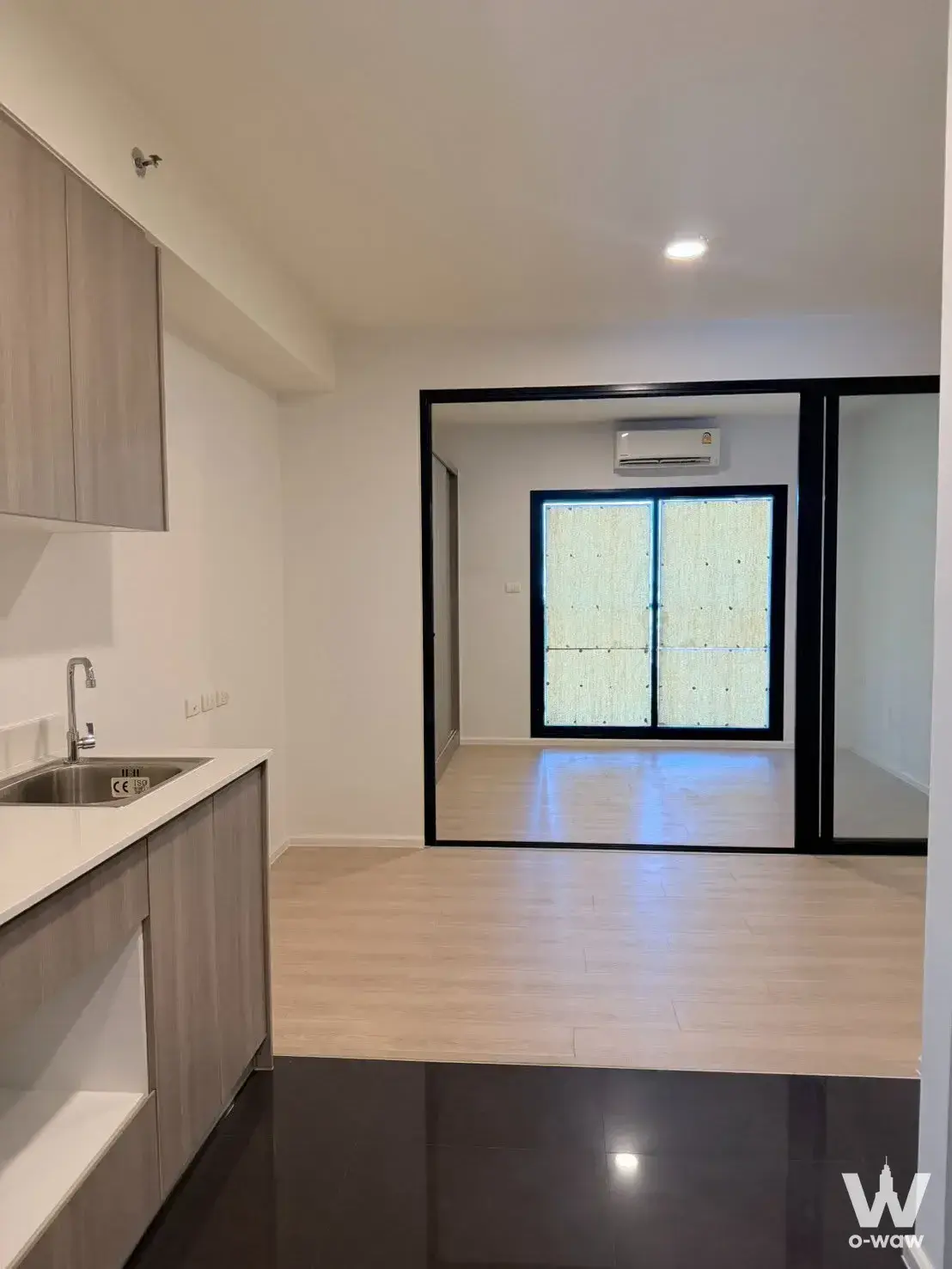 Modern unfurnished 1-bed condo for sale in A Space Mega One with grey kitchen cabinets and glass partition