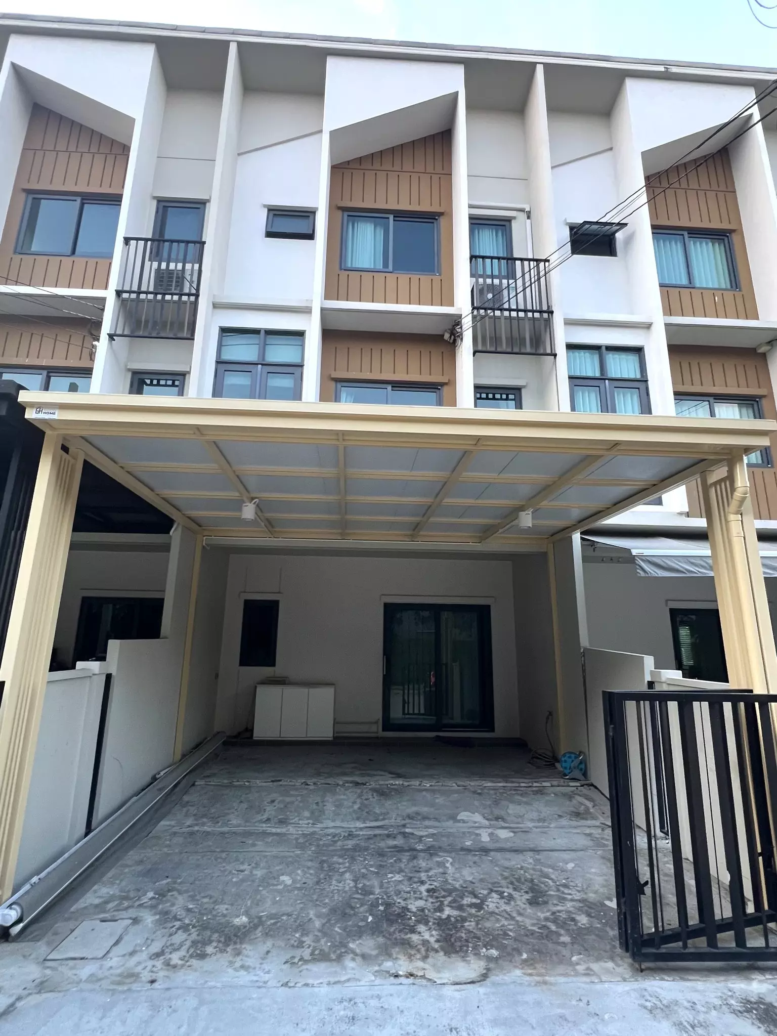 Modern 3-bed townhouse for rent at PLEX Onnut - Wongwaen featuring white facade, wood accents, and covered carport
