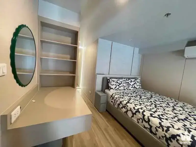 Minimalist bedroom with green accents and floating desk in a Culture Thonglor condo