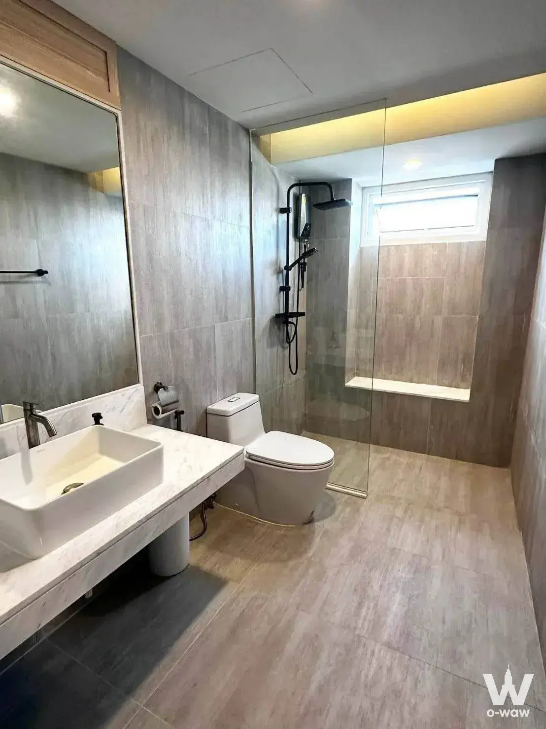 Modern bathroom in a 3-bed Riverside Villa condo with marble vanity, walk-in shower, and grey stone tiles