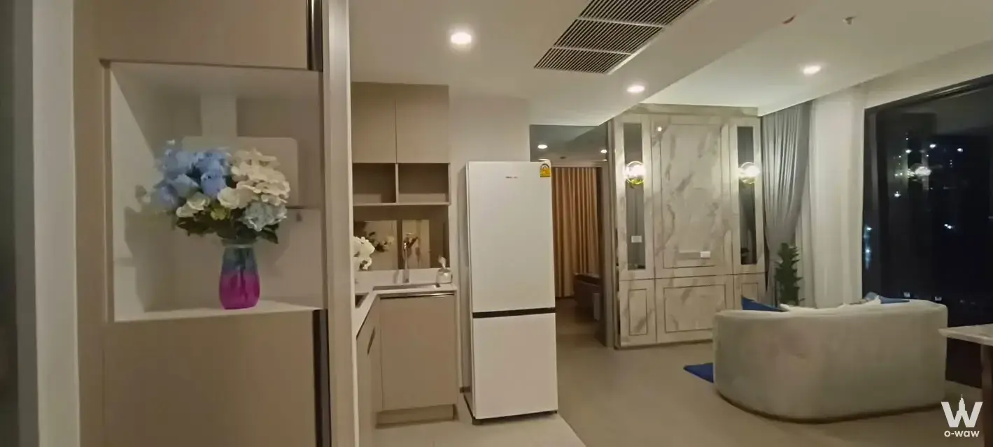 Furnished 2-bed condo living room in Coco Parc with magenta vase and city night view