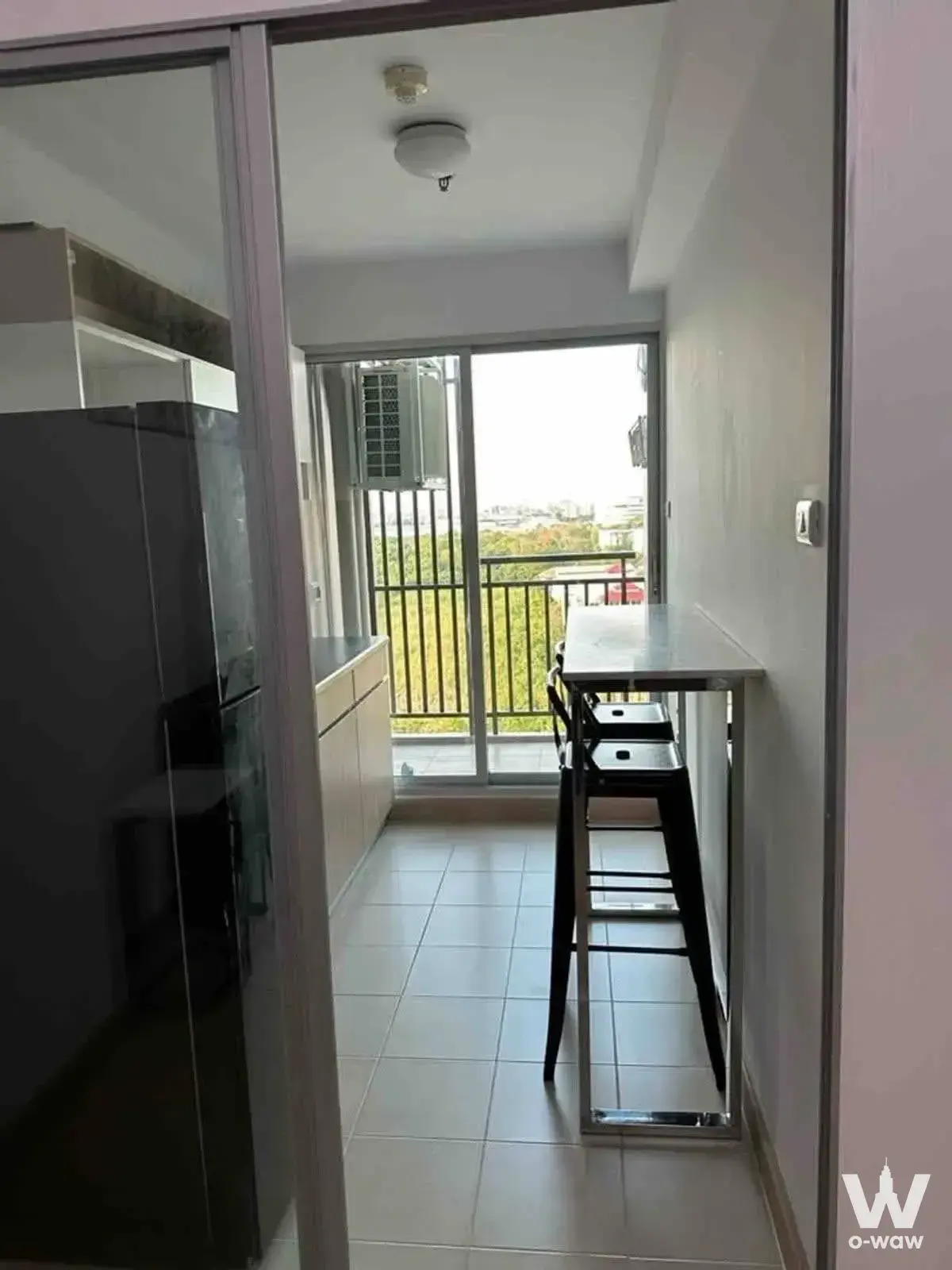 Narrow dining nook with high-top table and stools near the glass door in a Supalai Veranda Rama 9 condo