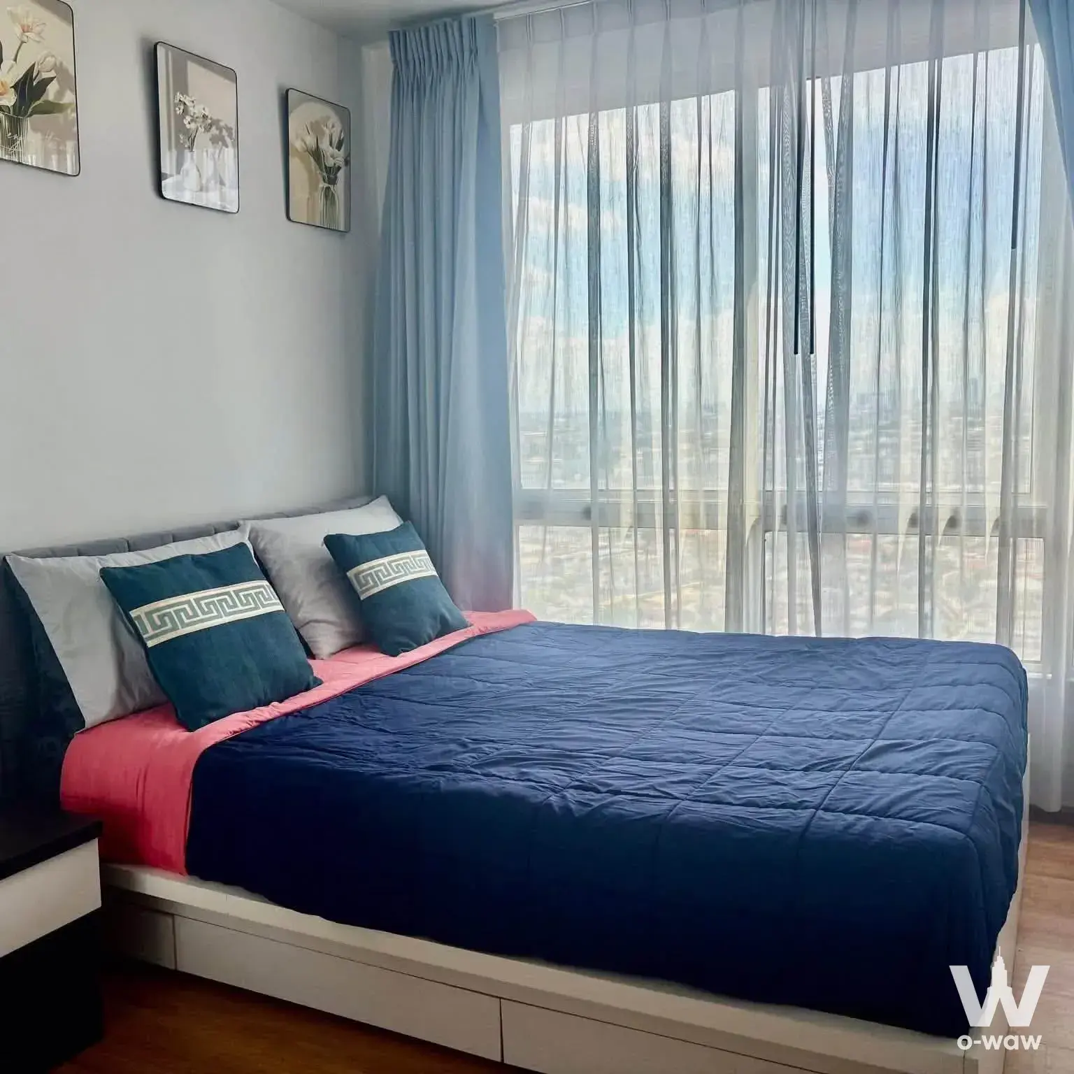 Furnished bedroom in THE BASE Sukhumvit 77 condo with navy comforter and high-floor city view