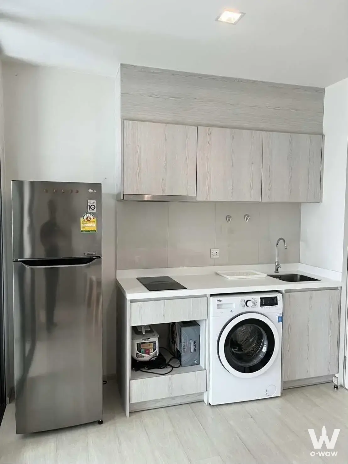 Compact kitchenette in a Life Sukhumvit 48 rental with induction cooktop and built-in washer