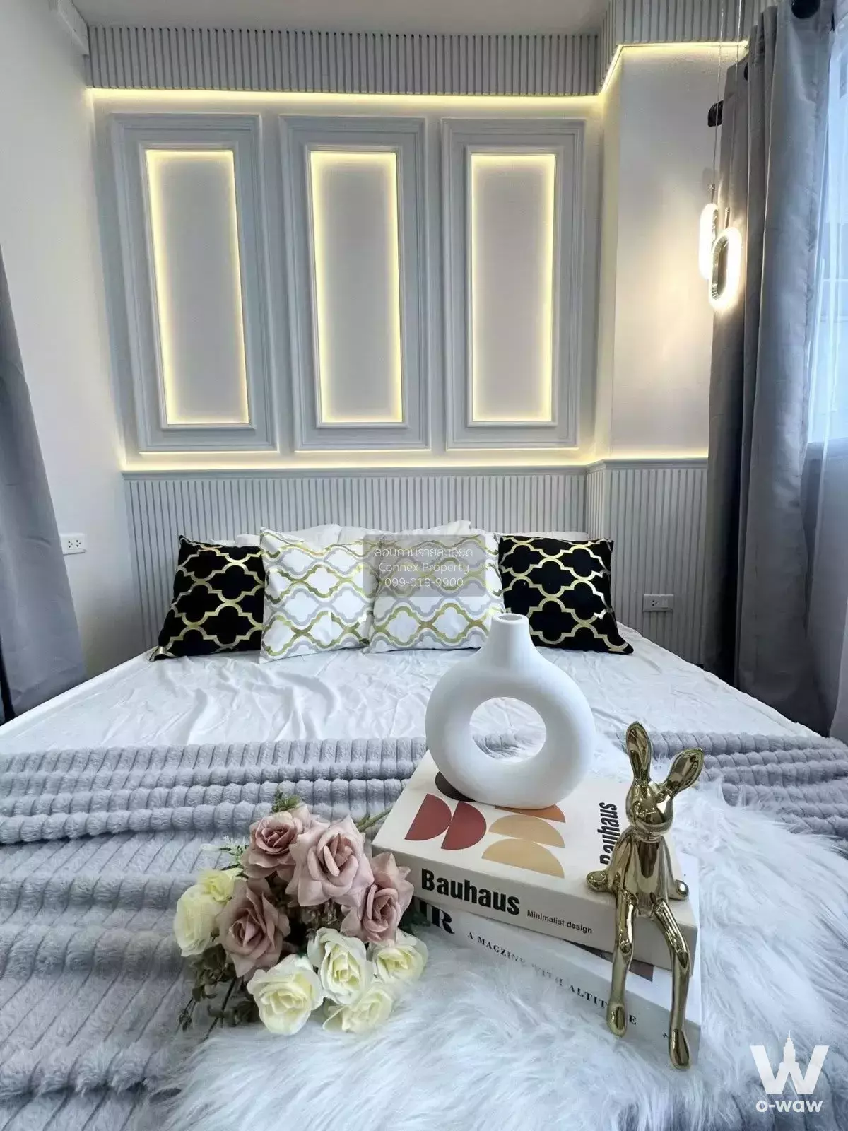 Modern bedroom at Ratchada Prestige Ladprao 48 with queen bed, grey beadboard headboard and gold accents