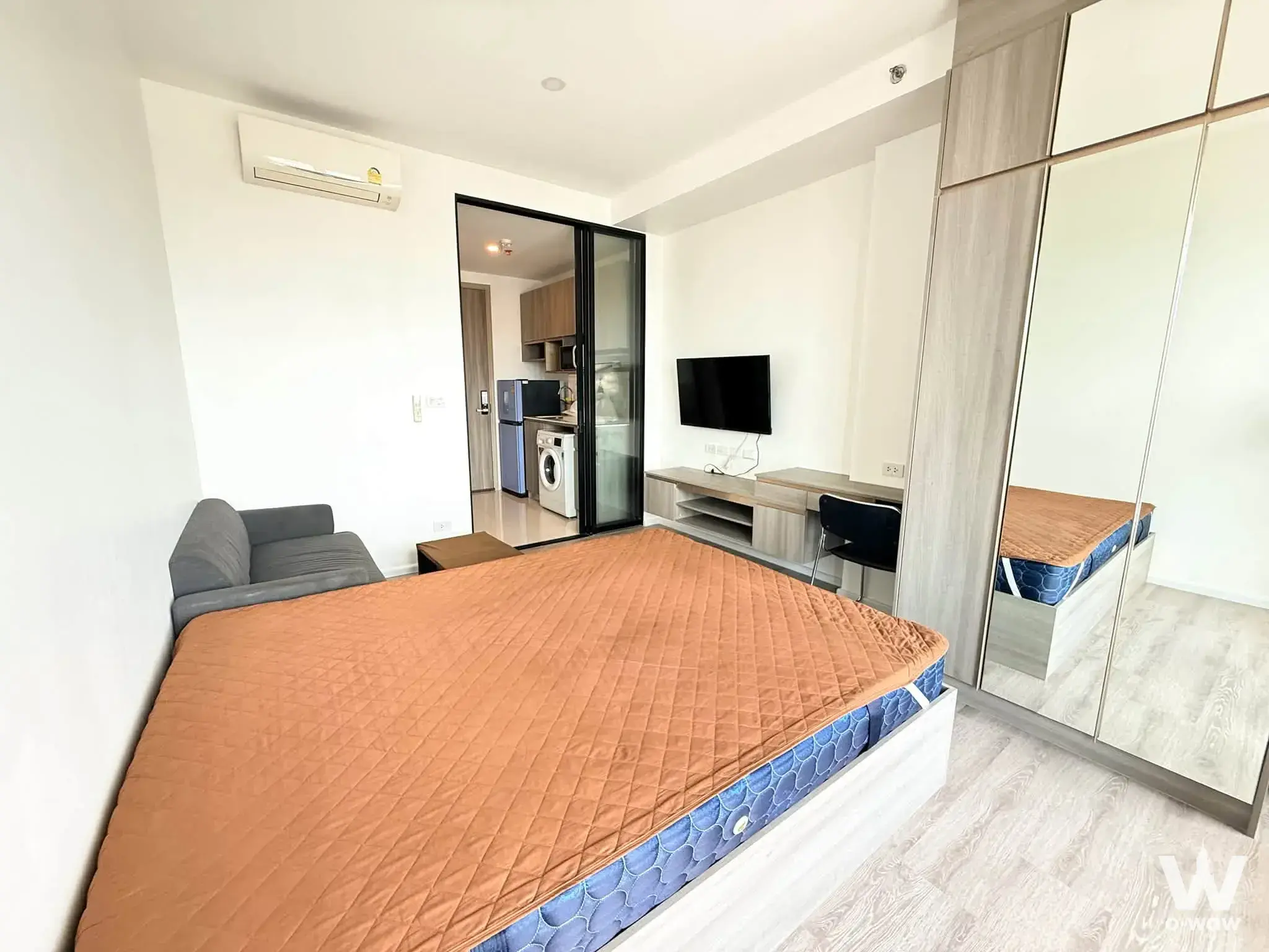 Queen bed in 1-bed condo for rent at Knightsbridge Sukhumvit-Thepharak with mirrored wardrobe and open kitchenette