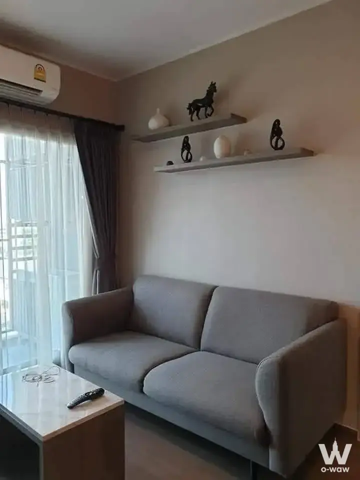 Modern living room in 2-bed condo for rent at Ideo Sukhumvit 93 with grey sofa, marble coffee table, and balcony view