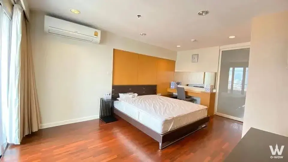 Master bedroom with orange wardrobe headboard in a 3-bed River Heaven condo