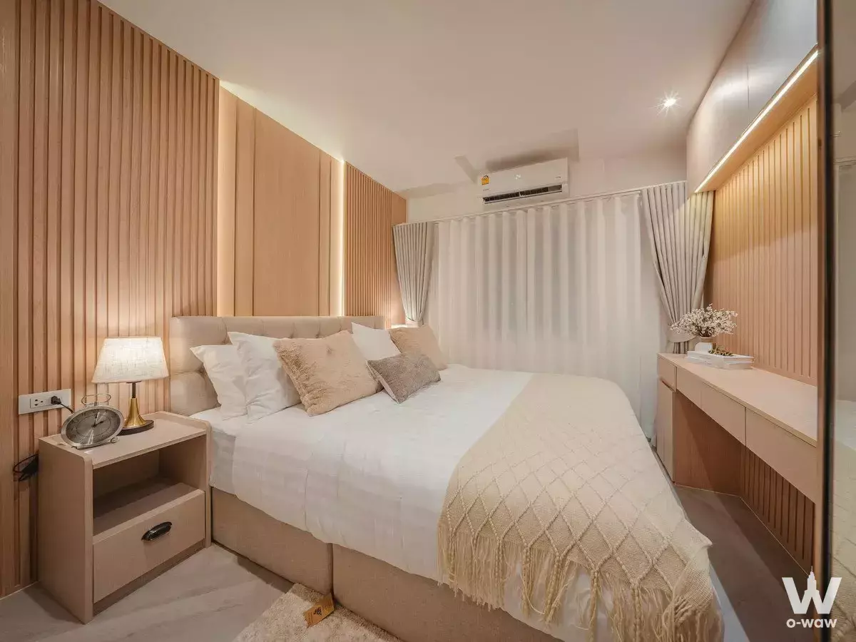 Spacious bedroom with wood slat accent wall in 3-bed condo for sale at Fortune CondoTown 1 Narathiwas