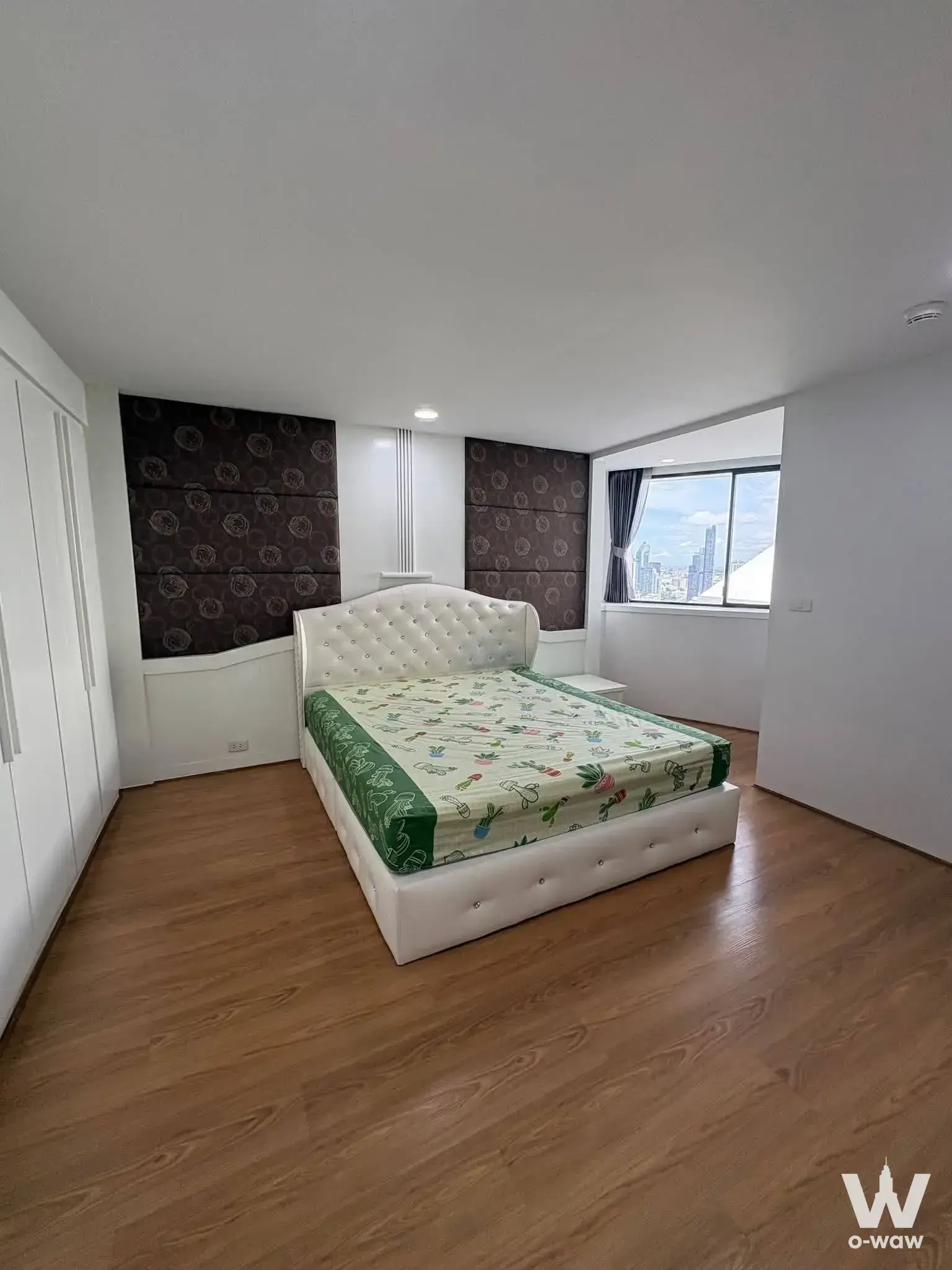 Queen bed with tufted headboard in this 3-bed Park24 rental featuring city skyline views
