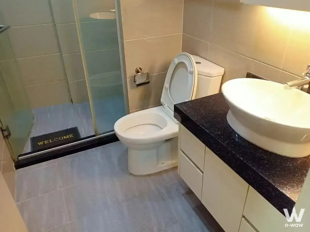 1-bed condo for sale in JRY Rama 9 Condominium bathroom with glass shower enclosure, vessel sink, and grey wood-look tiles