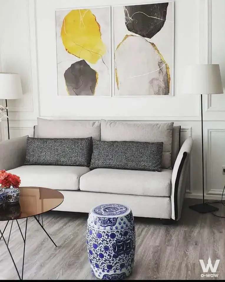 Modern 1-bed condo living room in 333 Riverside with grey sofa and abstract art