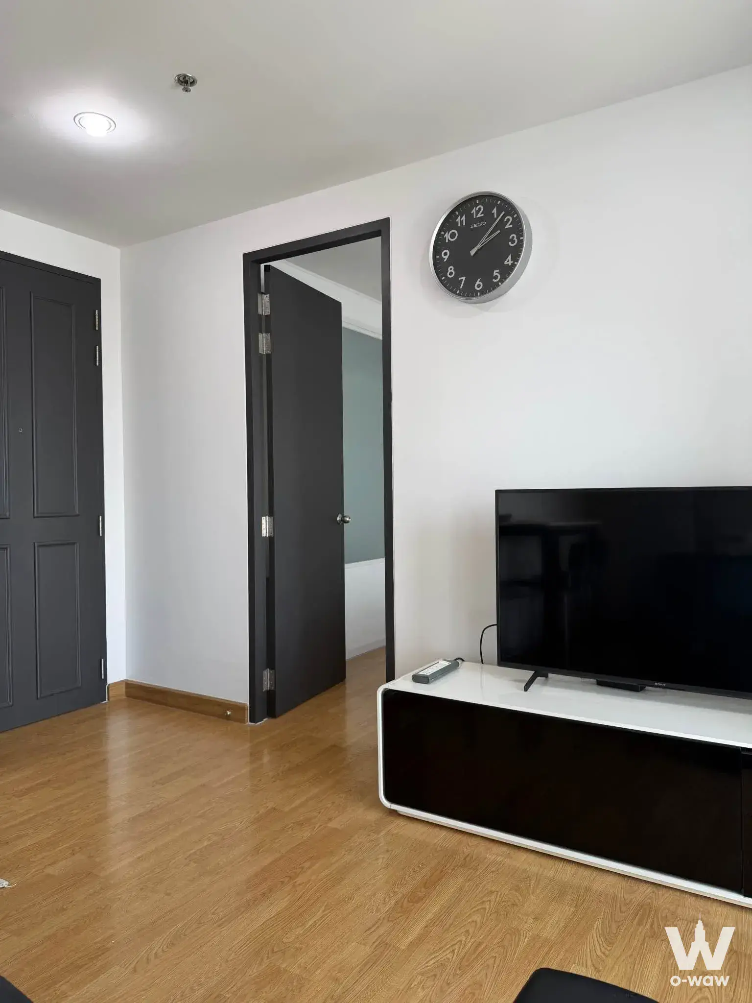 Unfurnished living room with media console and TV in The Parkland Grand Taksin one-bed condo