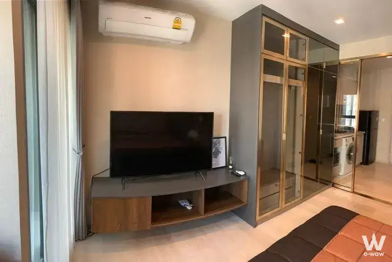 Furnished bedroom in Life One Wireless with a floating media console and large illuminated wardrobe