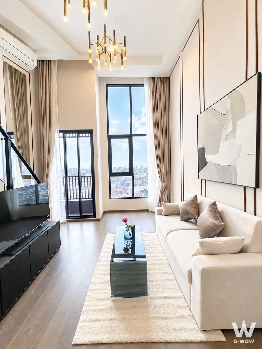 Living room in Park Origin Chula-Samyan for rent has a cream sofa and high-floor city view