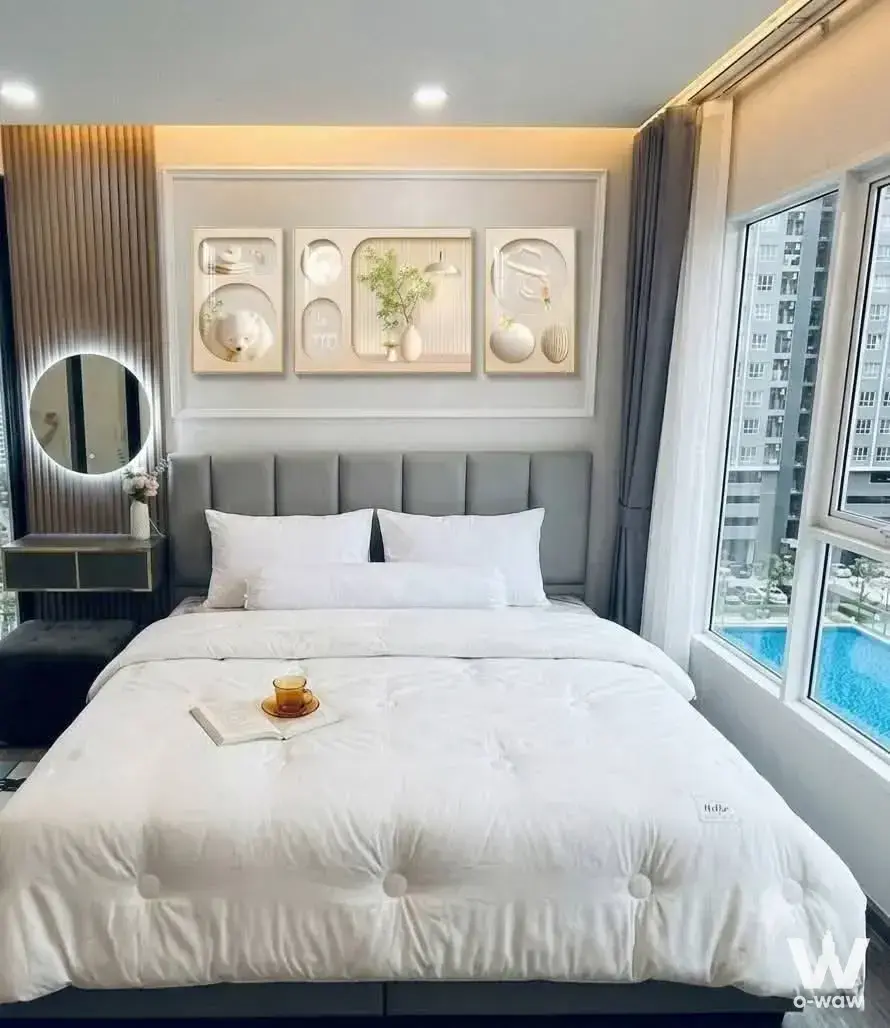 Queen bed with grey headboard in a Regent Home Bangna condo bedroom featuring wood slat walls and pool views